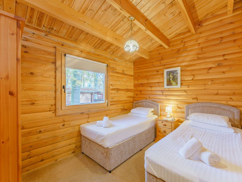 A bedroom with two beds and a window at Cedar Lodge (Pet) Louth