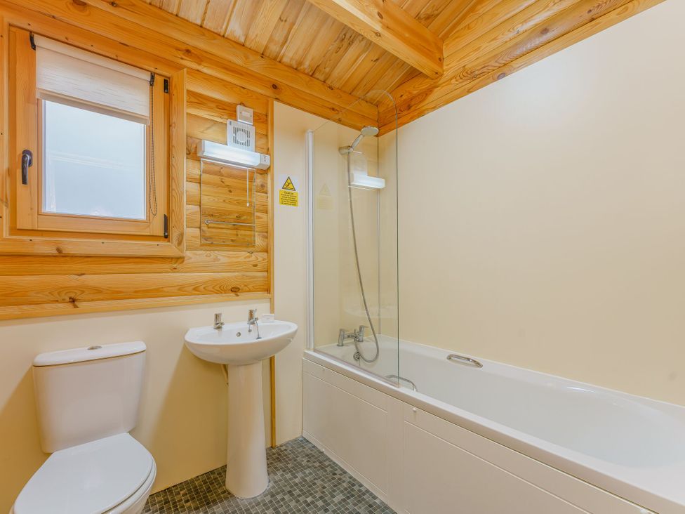 A bathroom with a bathtub, sink, and toilet at Cedar Lodge (Pet) in Louth