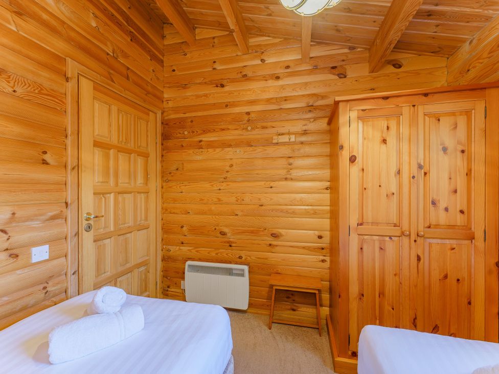 A bedroom with a bed, wardrobe, and door at Cedar Lodge (Pet) Louth
