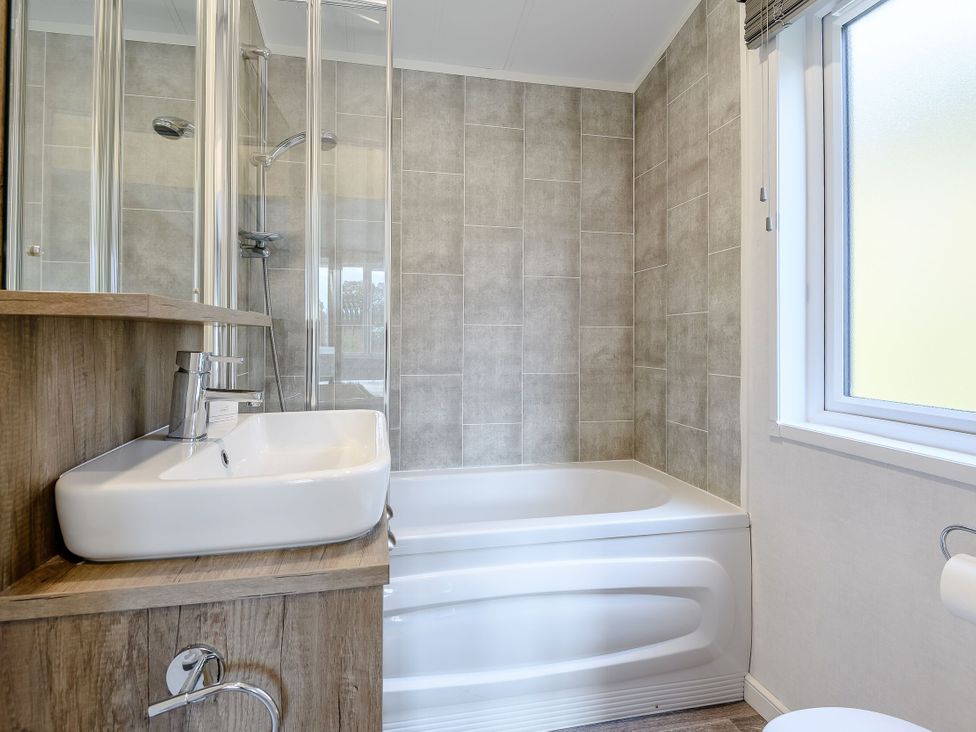 A bathroom with a bathtub and shower at Elsham Lodge (Pet) in Louth