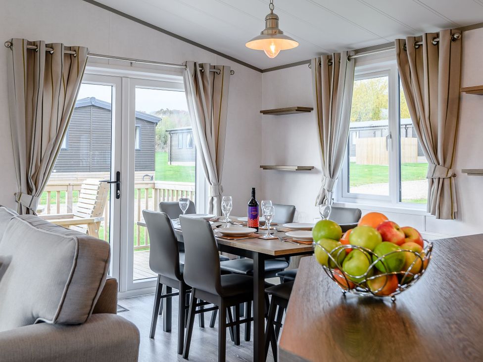 A dining room with a table set near a window at Elsham Lodge (Pet) in Louth
