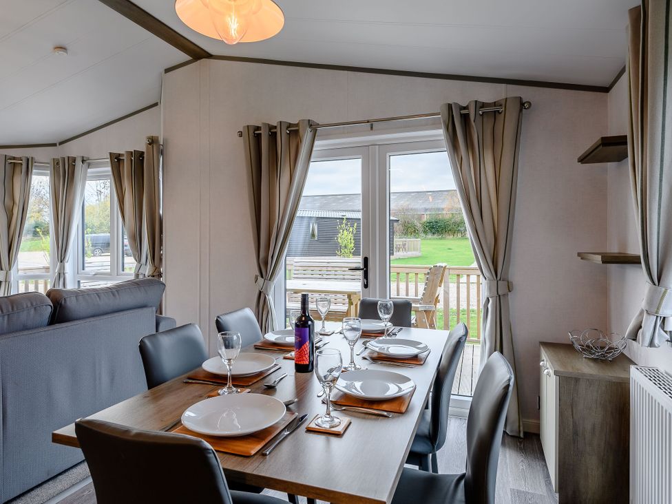 A dining room with a table and chairs at Elsham Lodge (Pet) in Louth