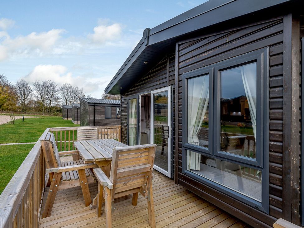 A patio with table and chairs at Elsham Lodge (Pet) Louth