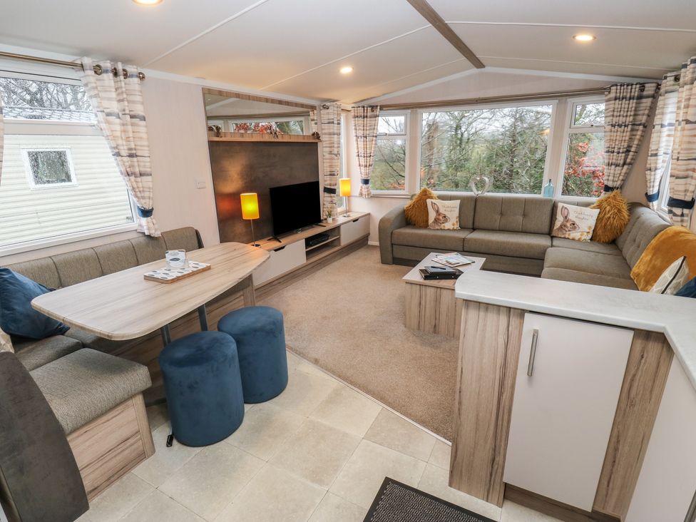 A living room with a couch and television at Woodland View 