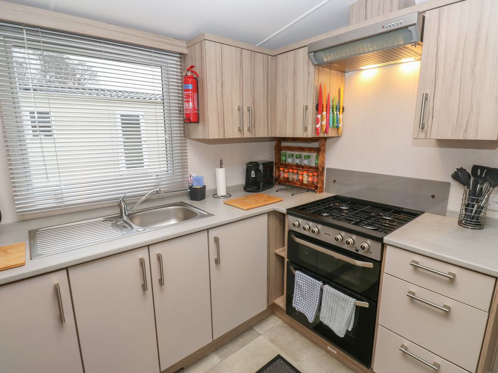 A kitchen with oven, sink, and cabinets at Woodland View