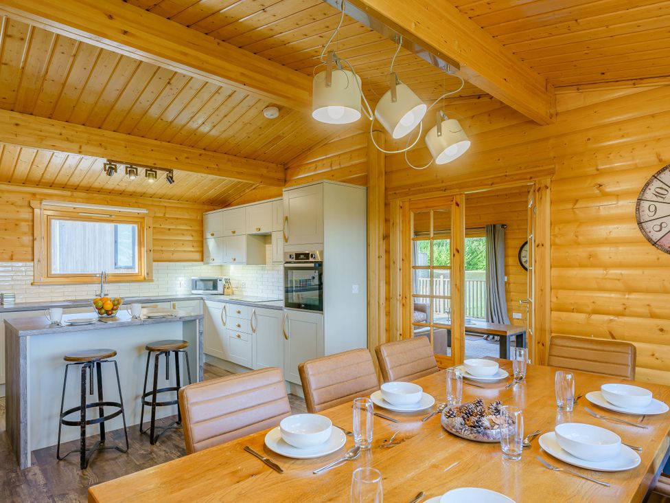 A kitchen with a dining area and bar stools at Hazel Lodge in Louth