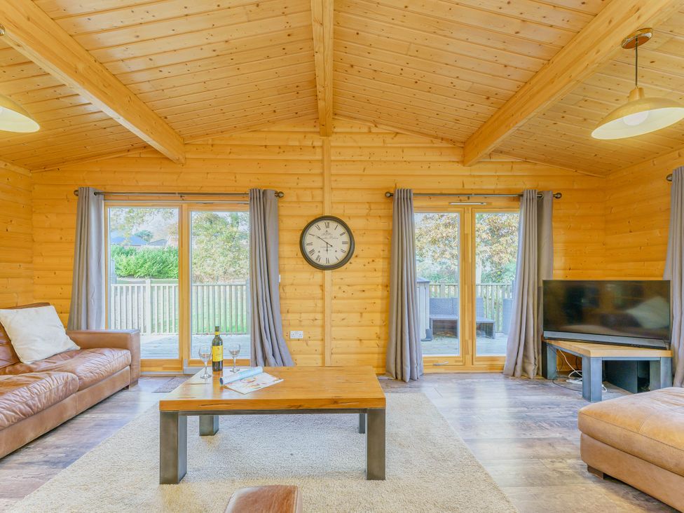 A living room with a sofa, coffee table, and television at Hazel Lodge in Louth