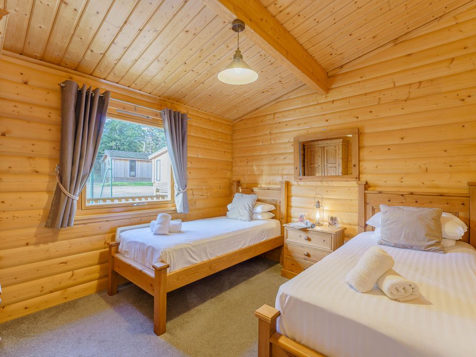 A bedroom with two beds and a window at Hazel Lodge in Louth