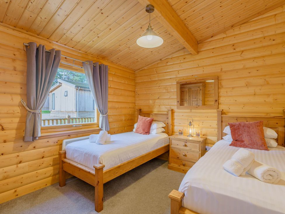 A bedroom with two beds and a window at Hazel Lodge in Louth