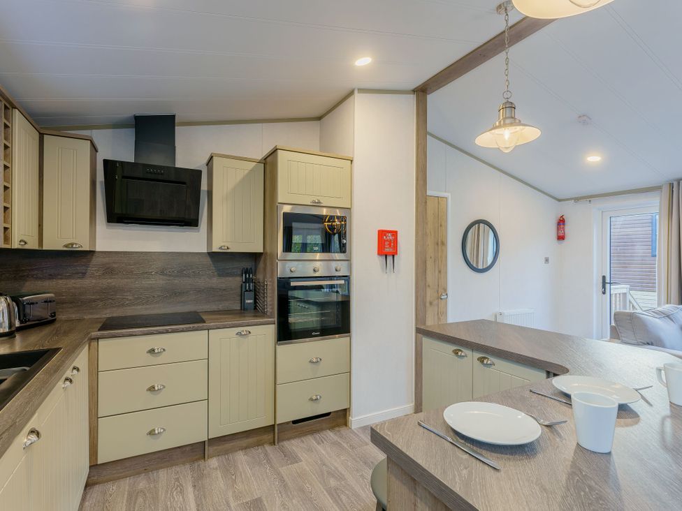 A kitchen with cabinets, appliances, and dining area at Brayford Lodge in Louth