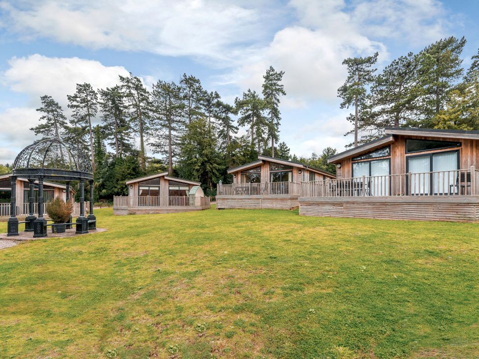 Several wooden lodges and a gazebo on grass at Retreat Lodge 4 in Louth