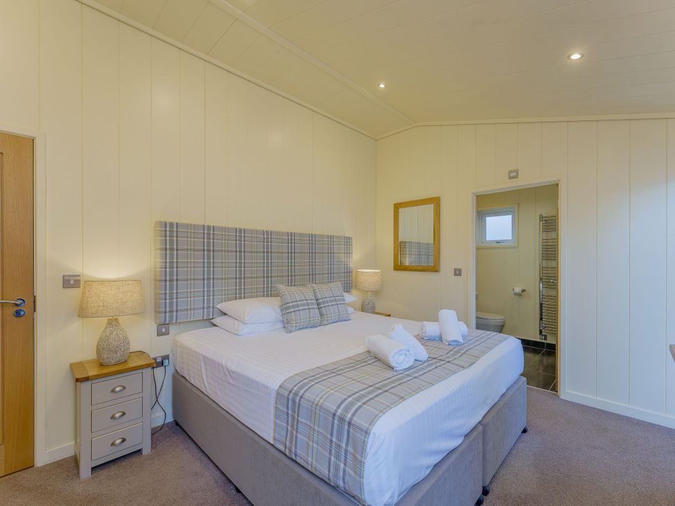 A bedroom with a bed and nightstand at Retreat Lodge 4 in Louth