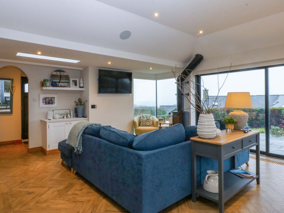 A living room with a sofa and television at Bryn Mor Cottage in Mynytho near Llanbedrog