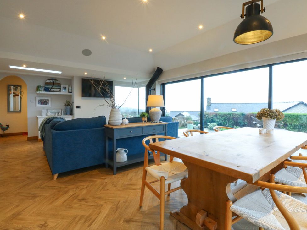 A living area with a dining table and sofa at Bryn Mor Cottage in Mynytho near Llanbedrog