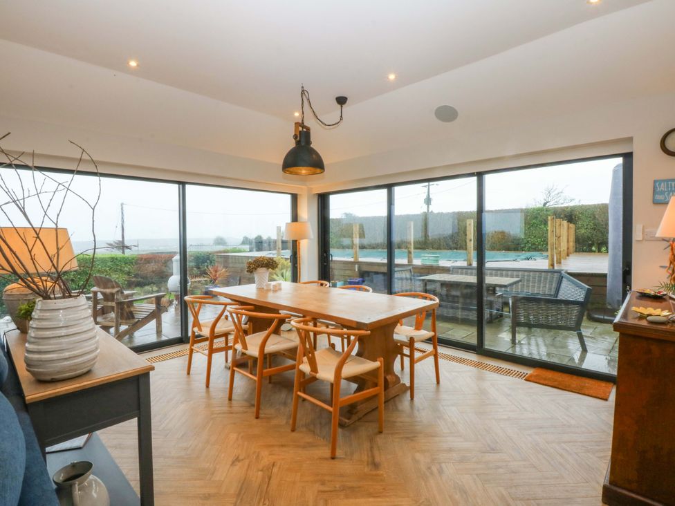 A dining area with a table and chairs at Bryn Mor Cottage in Mynytho near Llanbedrog