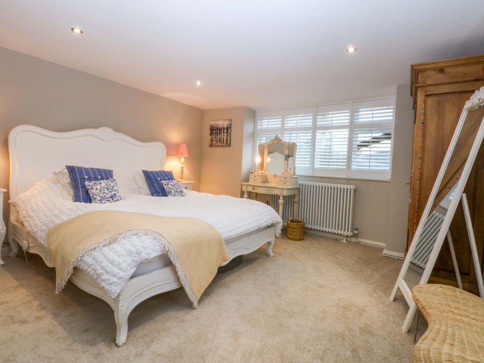 A bedroom with a bed and dressing table at Bryn Mor Cottage in Mynytho near Llanbedrog