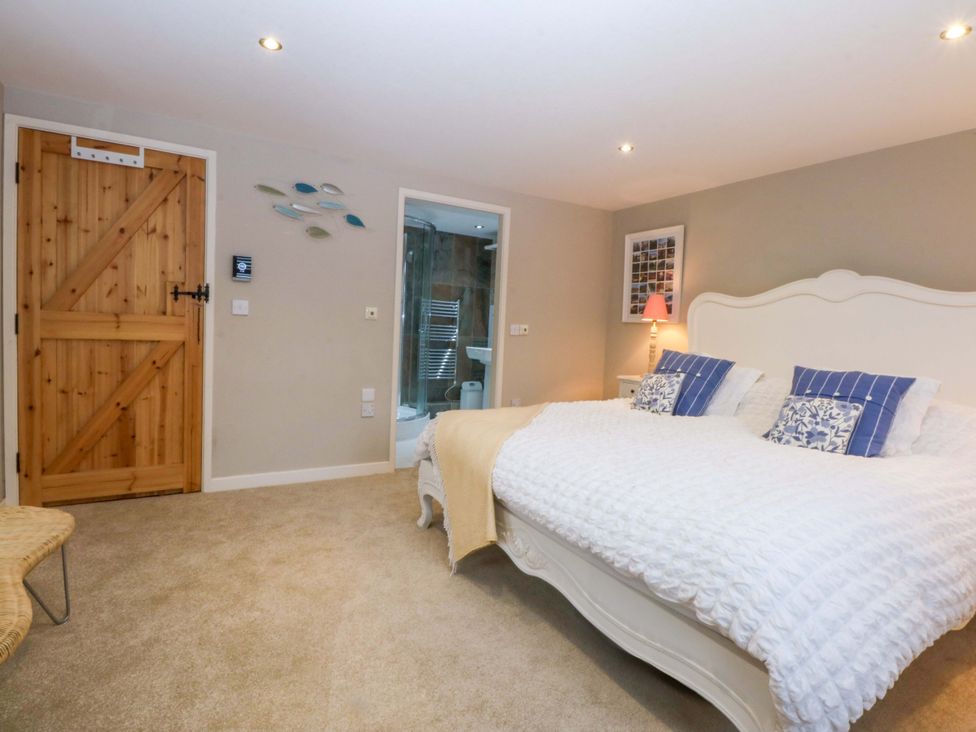 A bedroom with a bed and nightstand at Bryn Mor Cottage in Mynytho near Llanbedrog