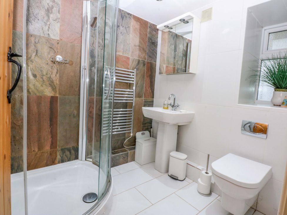 A bathroom with a shower and wash basin at Bryn Mor Cottage in Mynytho near Llanbedrog