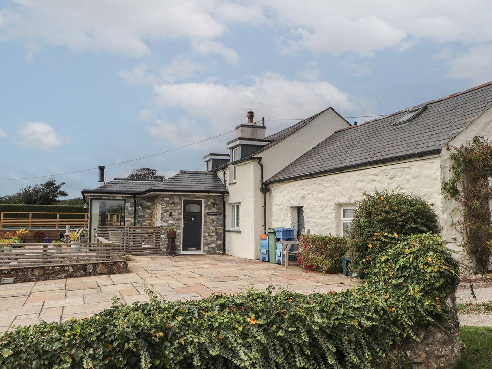 An outdoor area with a house and patio at Bryn Mor Cottage in Mynytho near Llanbedrog