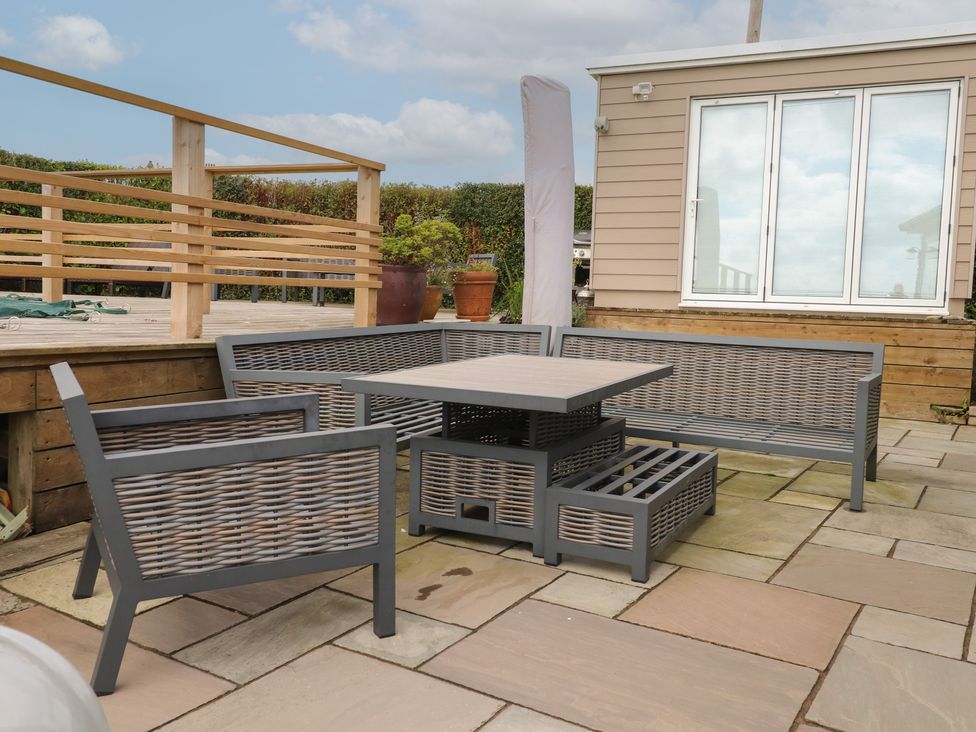 An outdoor area with seating and a table at Bryn Mor Cottage in Mynytho near Llanbedrog