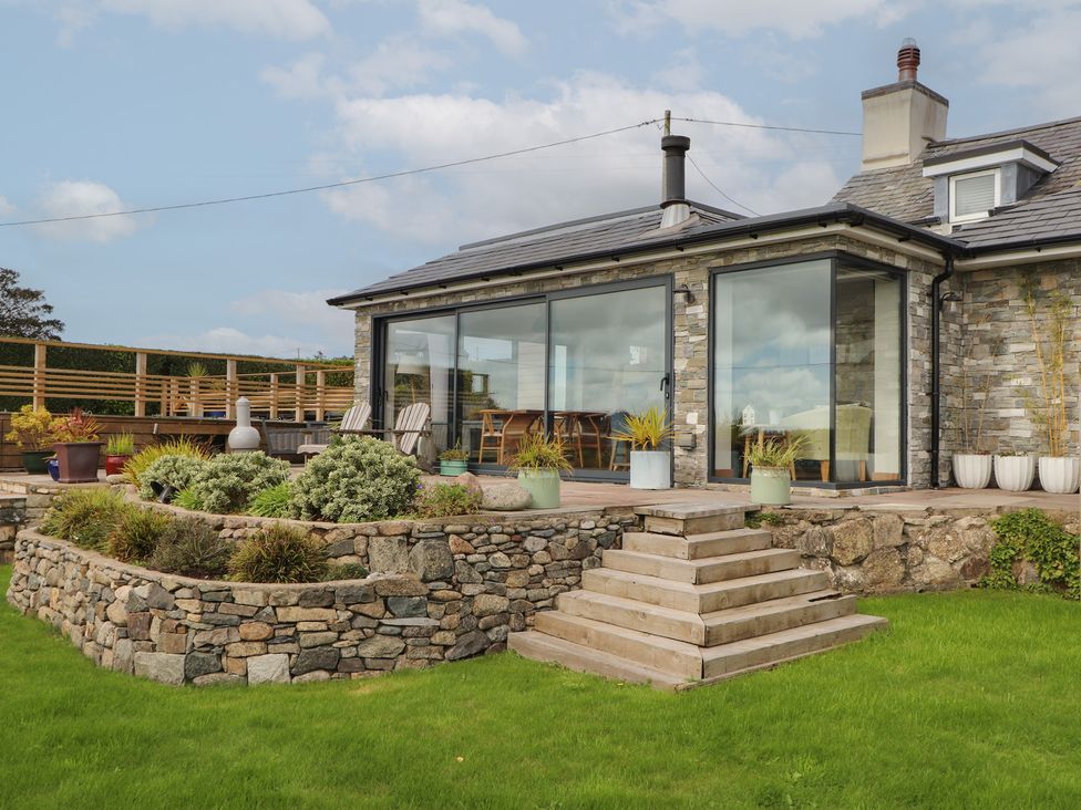 An outdoor area with stone steps and glass doors at Bryn Mor Cottage in Mynytho near Llanbedrog