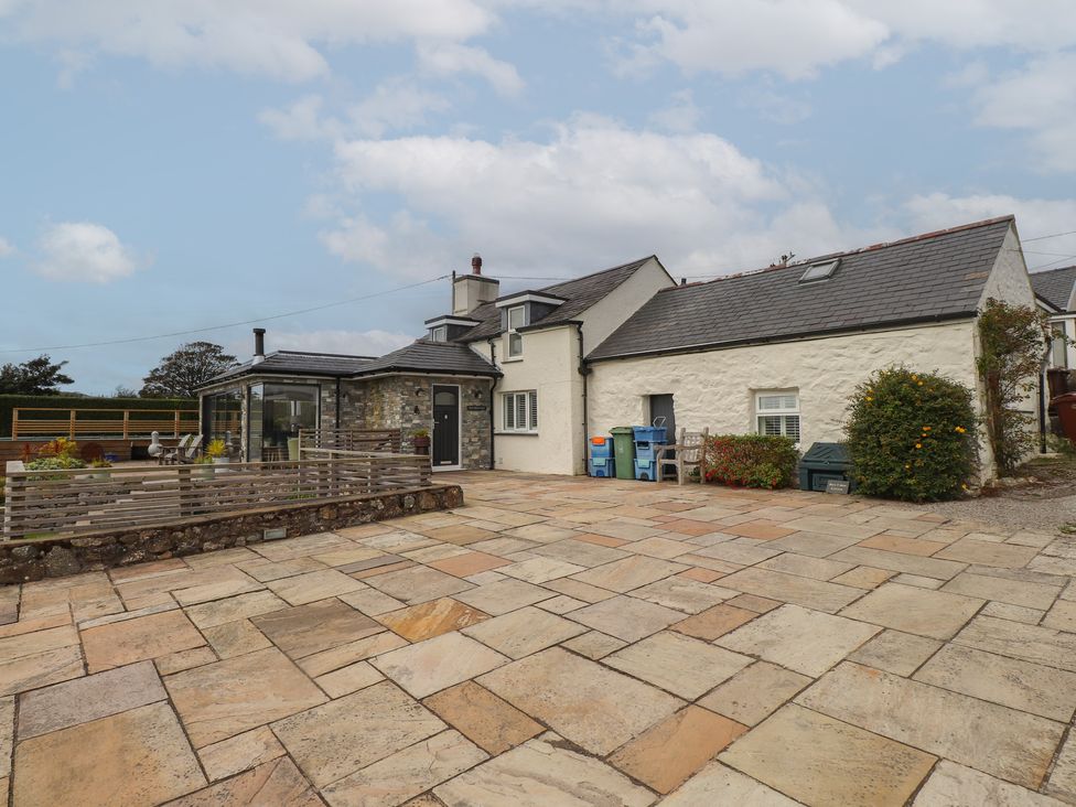 An outdoor view of a house with a terrace at Bryn Mor Cottage Mynytho near Llanbedrog
