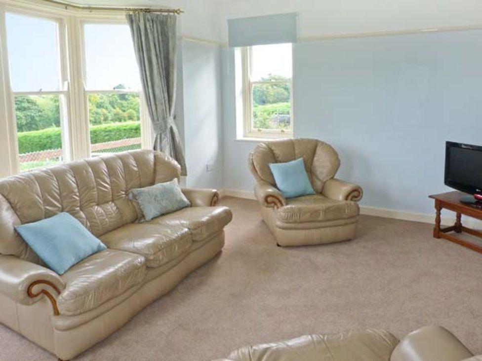 A living room with a sofa and armchair in Priory View Ulverston