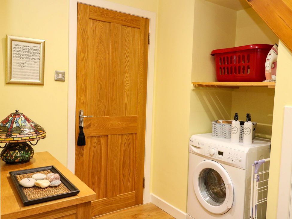 A laundry room with a washing machine and a shelf at 78 Findhorn in Forres