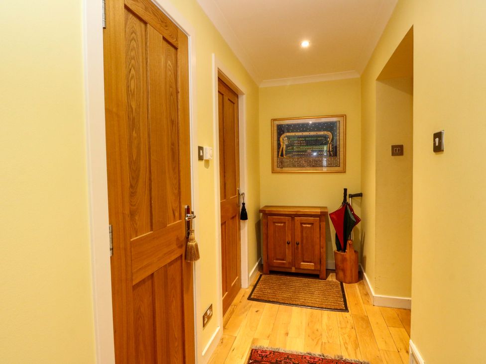 A hallway with doors and a table at 78 Findhorn in Forres