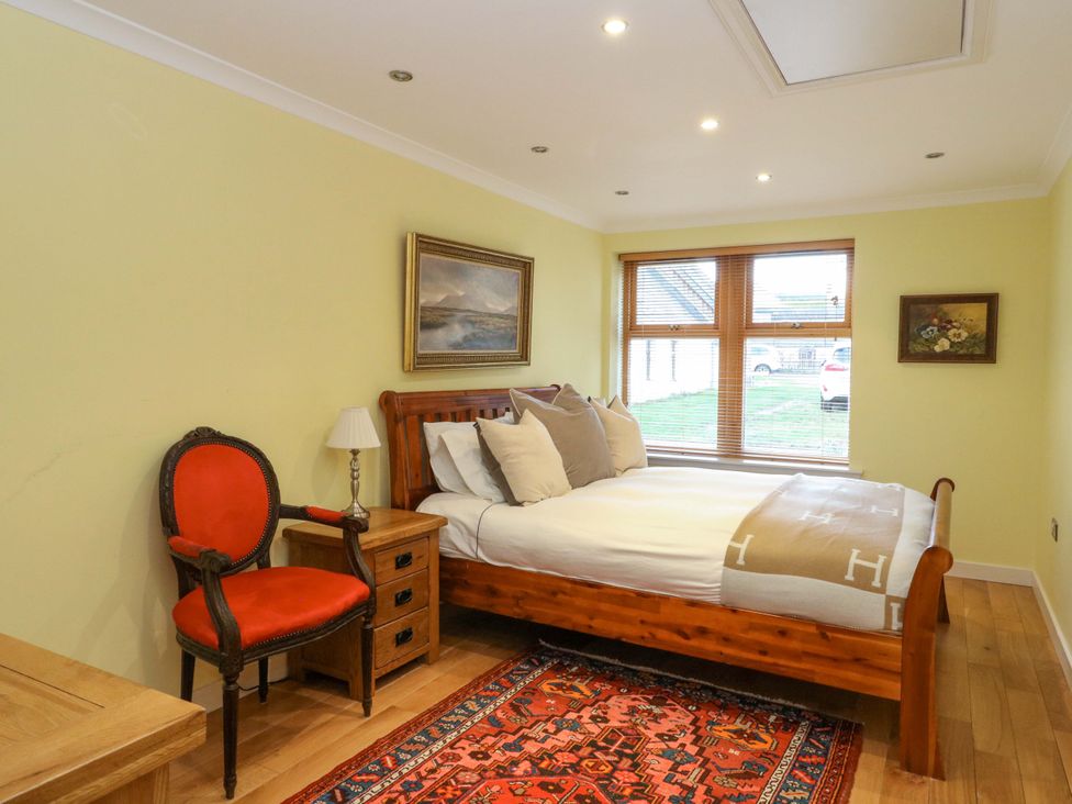 A bedroom with a bed, chair, and table at 78 Findhorn in Forres