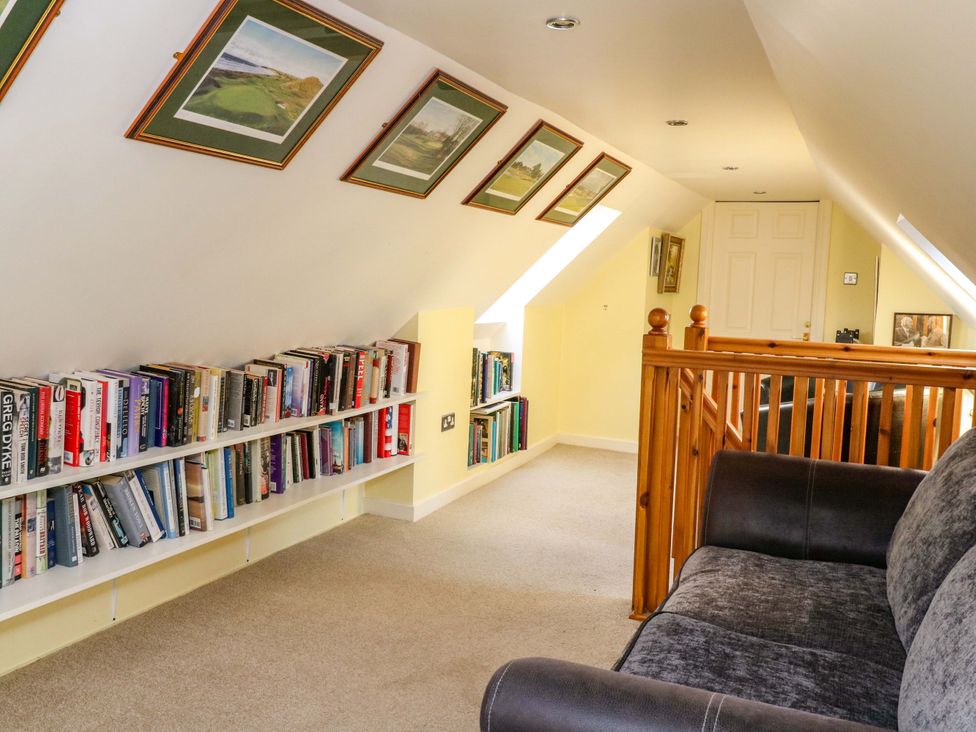 A landing area with books on shelves and a sofa at 78 Findhorn in Forres