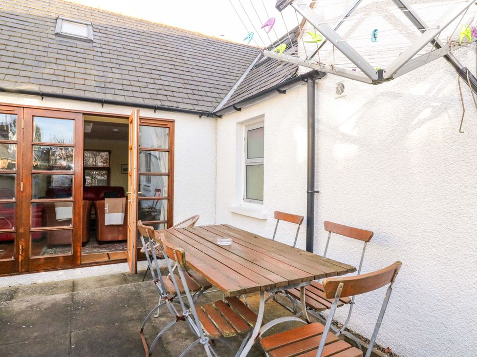 A patio area with a wooden table and chairs at 78 Findhorn, Forres