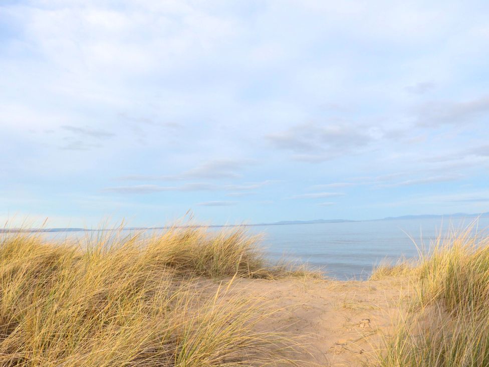 A view of the sea with grass and sand at 78 Findhorn in Forres