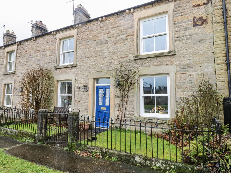 A house with a blue door and a garden at Ivy Cottage in West Burton