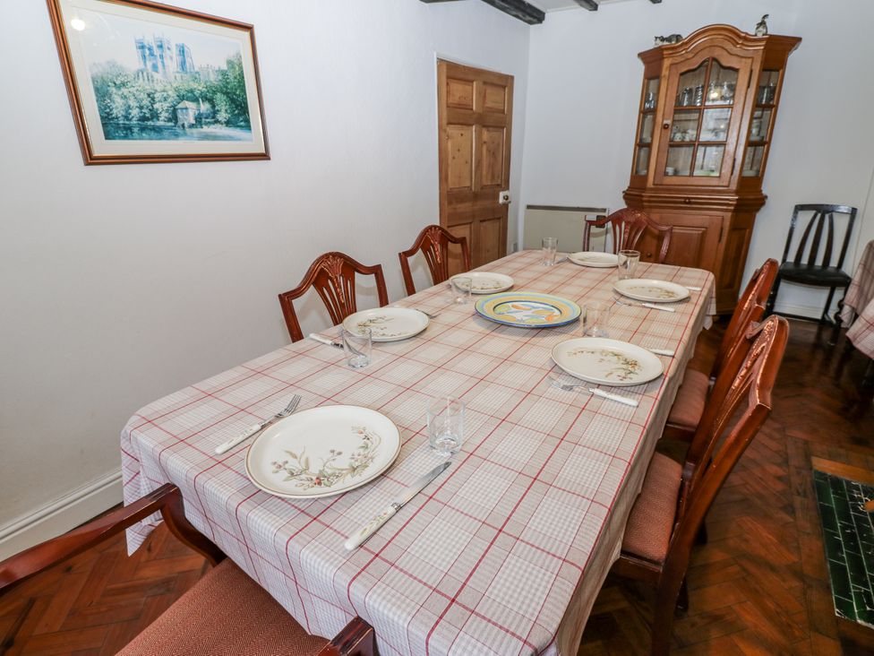 A dining room with a large table set for meals at Ivy Cottage in West Burton
