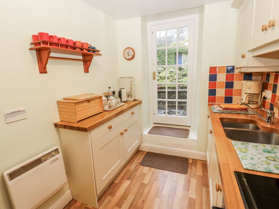A kitchen with a door and a coffee maker at Ivy Cottage in West Burton