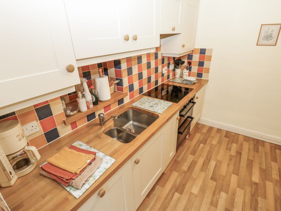 A kitchen with cabinets and a sink at Ivy Cottage in West Burton