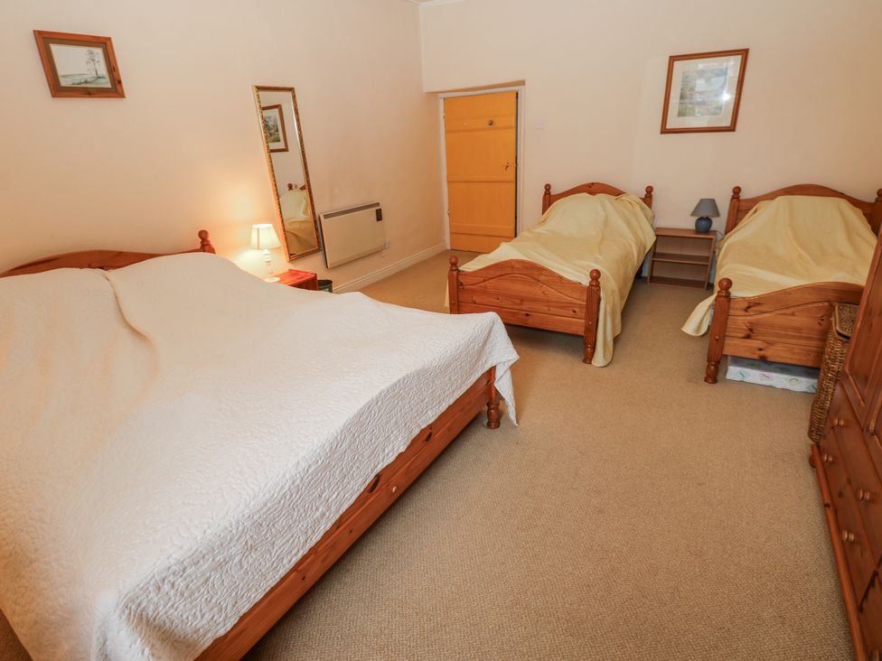 A bedroom with a double bed and two single beds at Ivy Cottage in West Burton