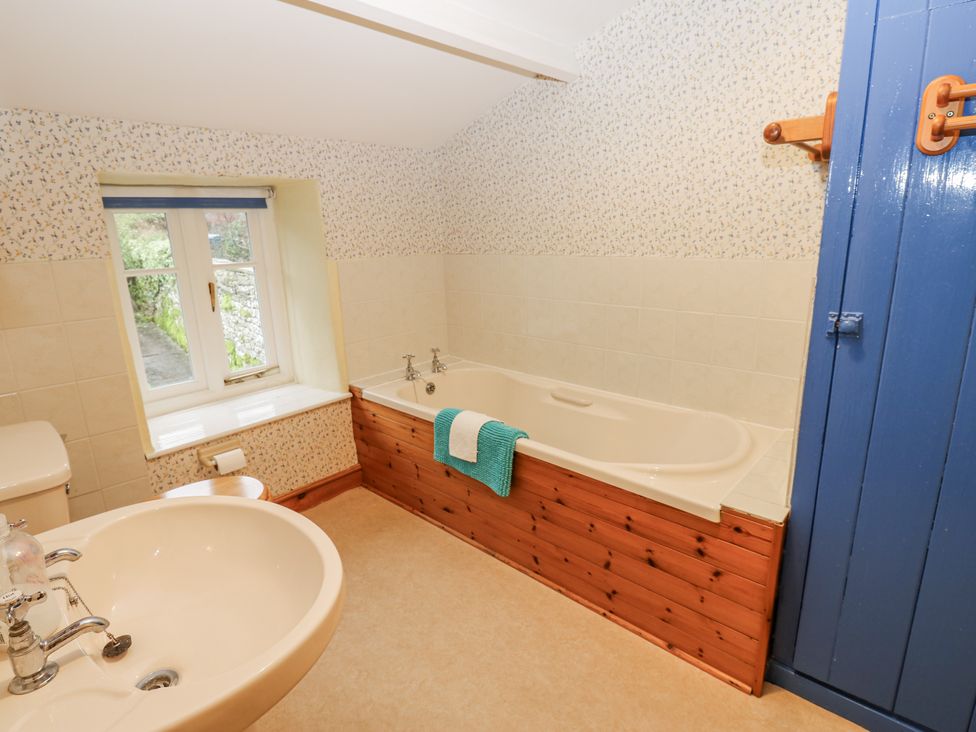 A bathroom with a bathtub and sink at Ivy Cottage West Burton