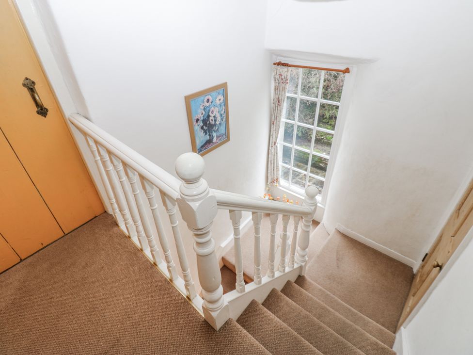 A staircase with a handrail and a window at Ivy Cottage in West Burton