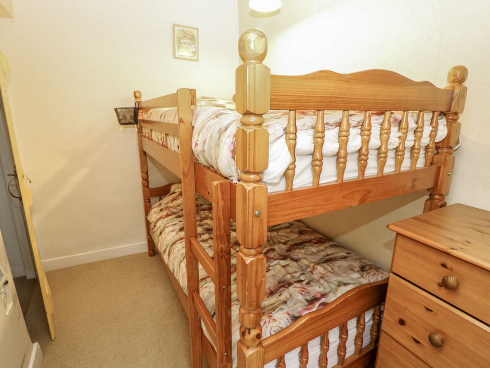 A bedroom with a bunk bed and wooden chest of drawers at Ivy Cottage in West Burton