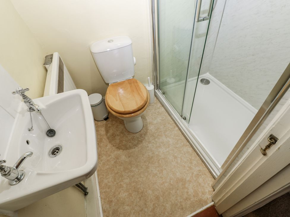 A bathroom with a sink, toilet, and shower at Ivy Cottage in West Burton