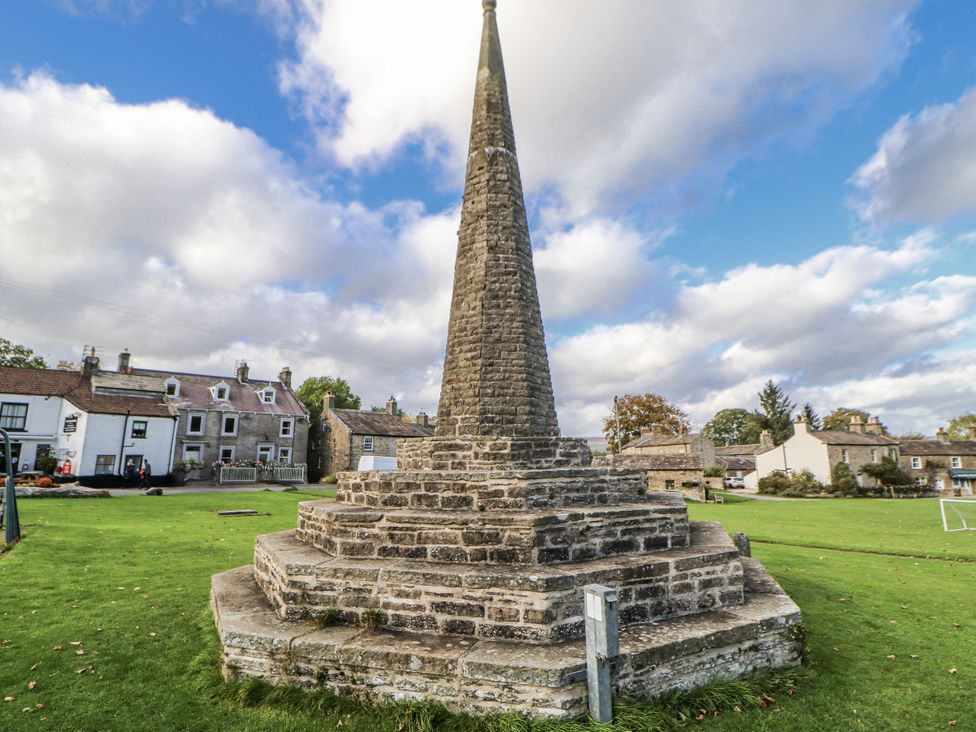 A stone monument in a grassy area at Ivy Cottage West Burton