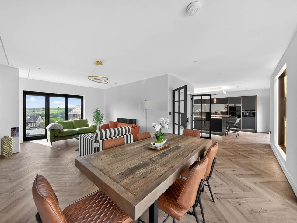 A living room with a dining table and chairs at Heddfan in Carmarthen