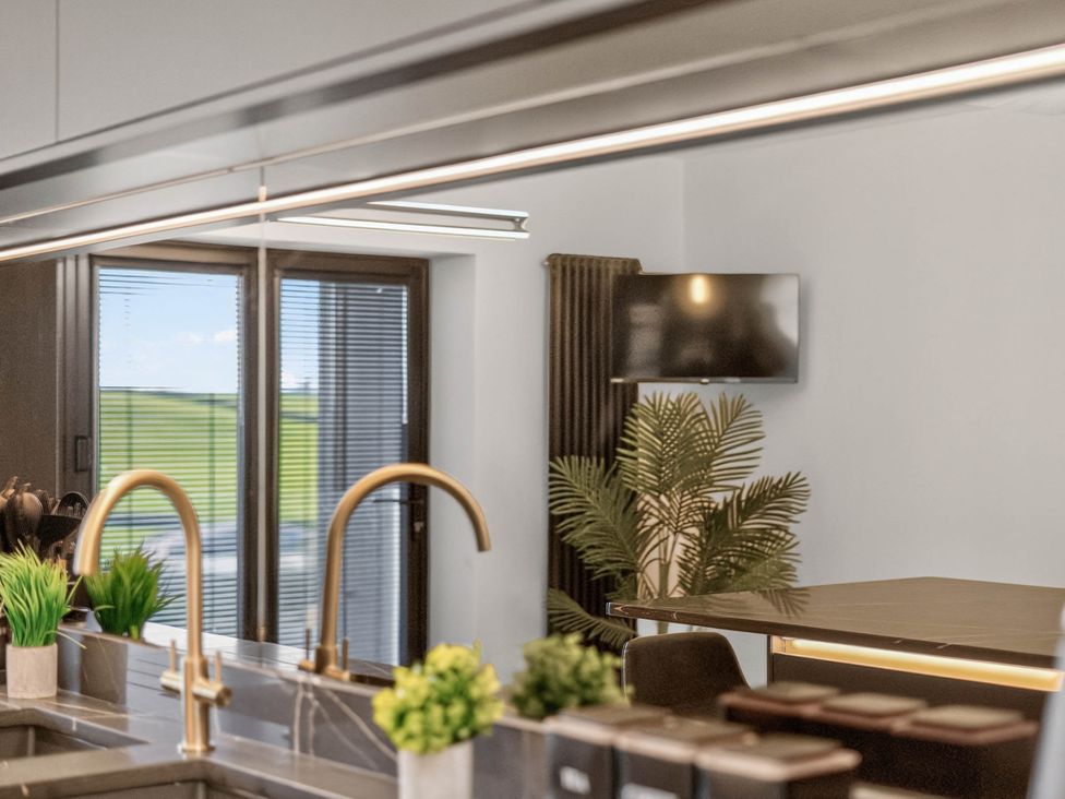 A kitchen with a sink and a television at Heddfan in Carmarthen