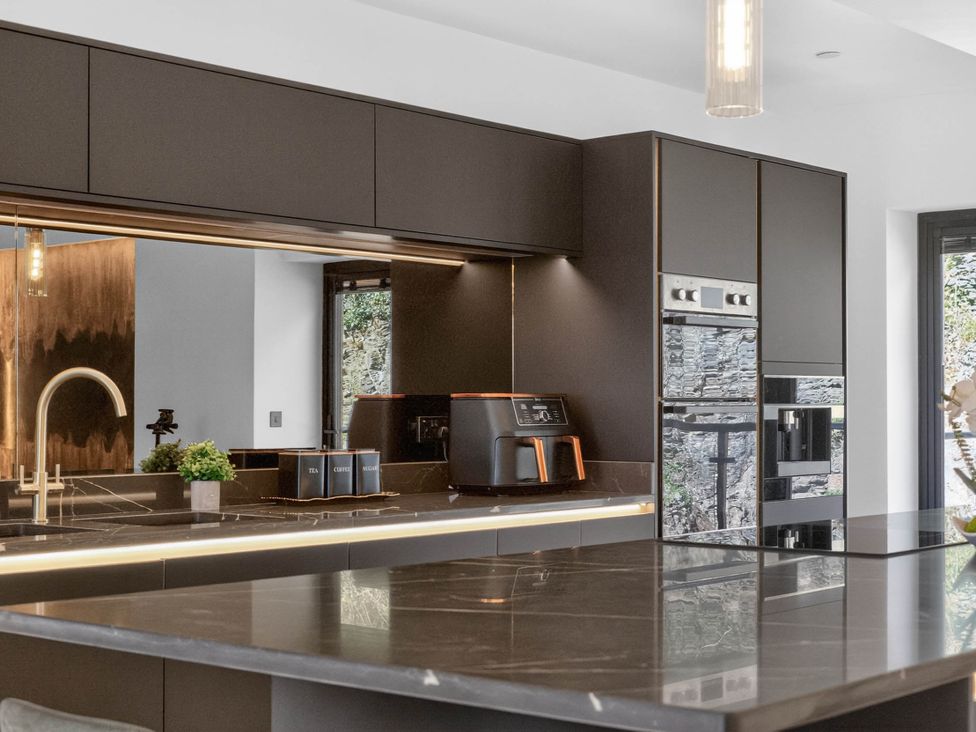 A kitchen with cabinets and a coffee machine at Heddfan in Carmarthen