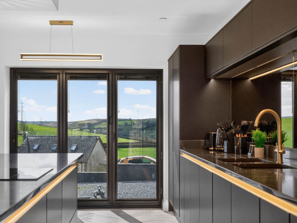 A kitchen with a view of hills and a car outside at Heddfan Carmarthen