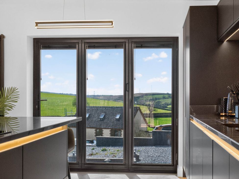 A kitchen with a window overlooking the countryside at Heddfan in Carmarthen