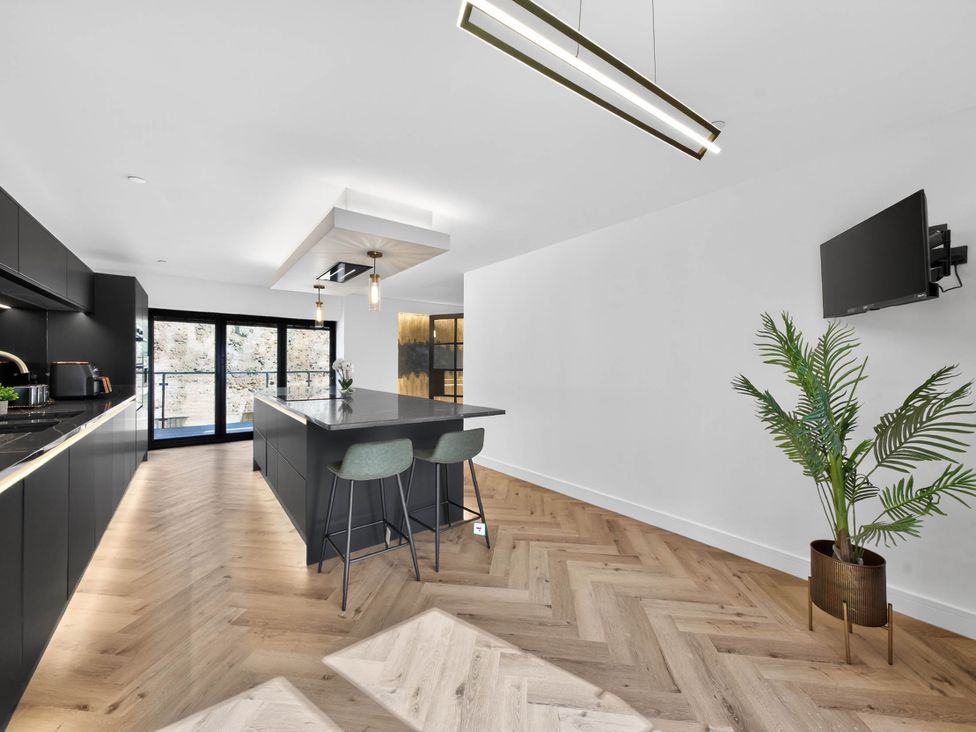 A kitchen with an island and bar stools at Heddfan in Carmarthen