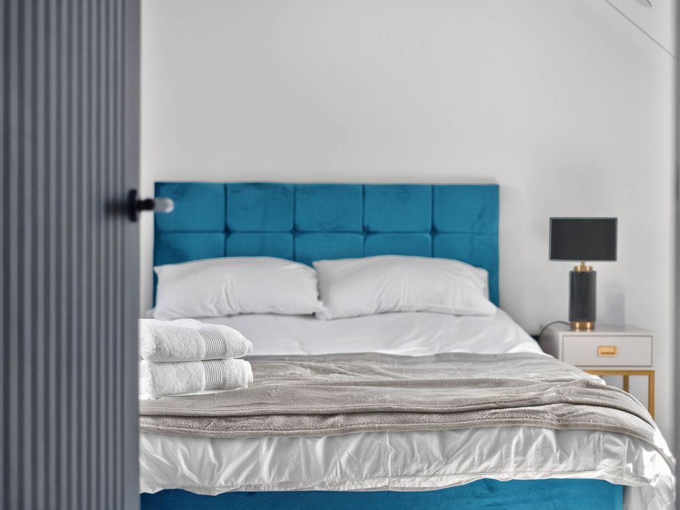 A bedroom with a bed and bedside table at Heddfan in Carmarthen